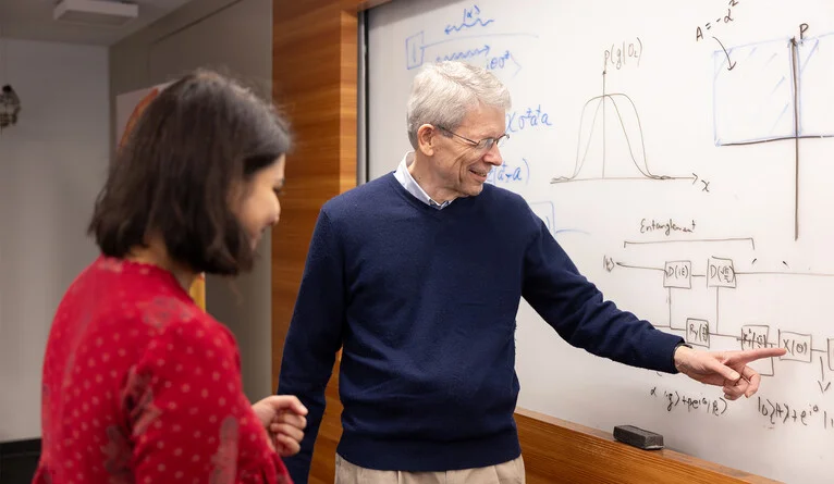 Girvin talks shop at a whiteboard at the Yale Quantum Institute. (Photo by Allie Barton)