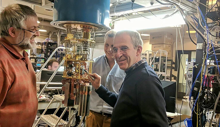 Senior research scientist Luigi Frunzio, left, Schoelkopf, and Devoret, working in the lab. (Photo by Brita Belli)