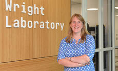 picture of scientist in front of sign of Wright Laboratory.