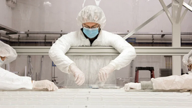 people in lab gear working in a clean room.